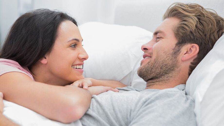 Ευτυχισμένη γυναίκα με άνδρα στο κρεβάτι